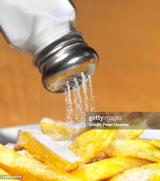 pouring salt shaker using too much salt - salière photos et images de collection