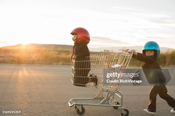 young business boys racing a shopping cart - fotostock fotografías e imágenes de stock