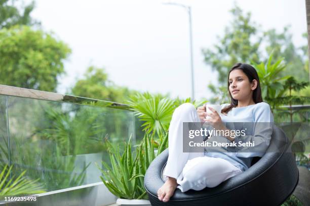 happy woman thinking at breakfast on vacation stock photo - balcony stock pictures, royalty-free photos & images