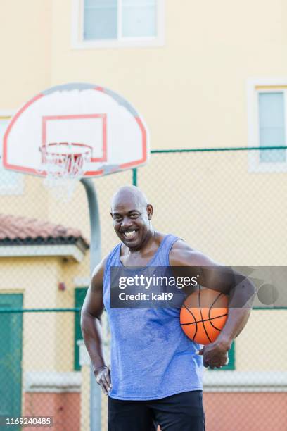 mature african-american man playing basketball - mature men playing basketball stock pictures, royalty-free photos & images