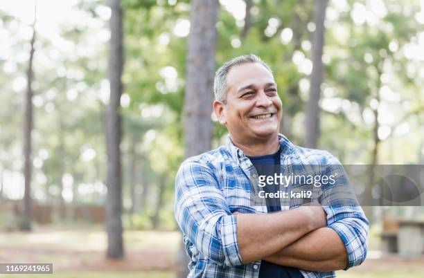 mature hispanic man wearing plaid shirt - mature men stock pictures, royalty-free photos & images