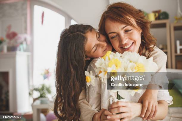 figlia che regala fiori a sua madre a casa - child giving gift foto e immagini stock