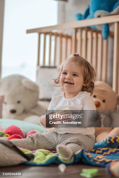 chica alegre jugando en su sala de juegos - baby cup fotografías e imágenes de stock