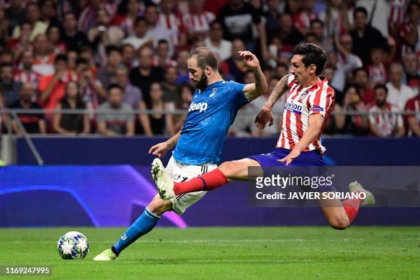 Atletico Madrid's Montenegrin defender Stefan Savic challenges Juventus' Argentinian forward Gonzalo Higuain during the UEFA Champions League Group D...