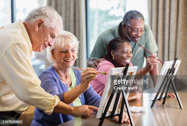 senior woman, friend painting on canvas, spouses look - house for an art lover stock pictures, royalty-free photos & images