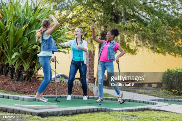 meisje met een misvormde arm, vrienden spelen miniatuur golf - minigolf stockfoto's en -beelden