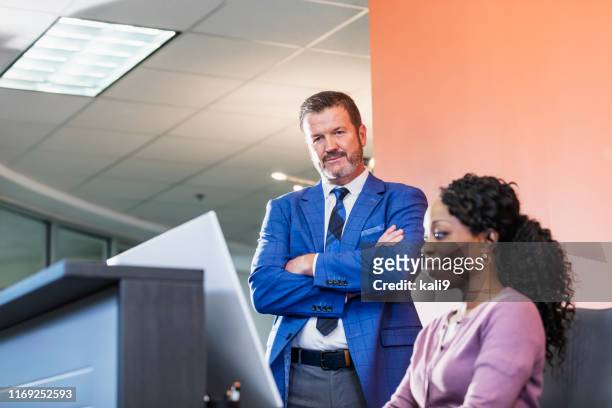 zwei personen in einem büro mit blick auf den computerbildschirm - boss over shoulder stock-fotos und bilder