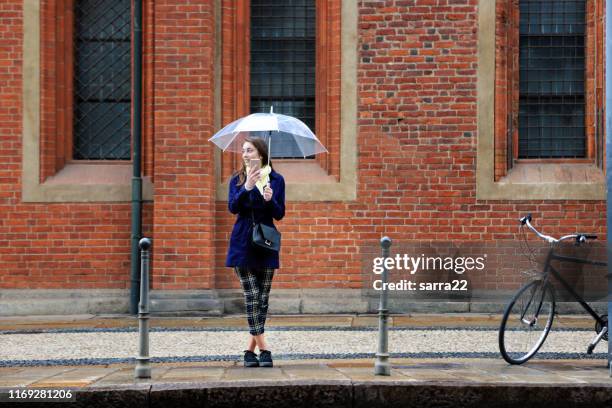 jonge vrouw met paraplu wachten - standing in the rain girl stockfoto's en -beelden