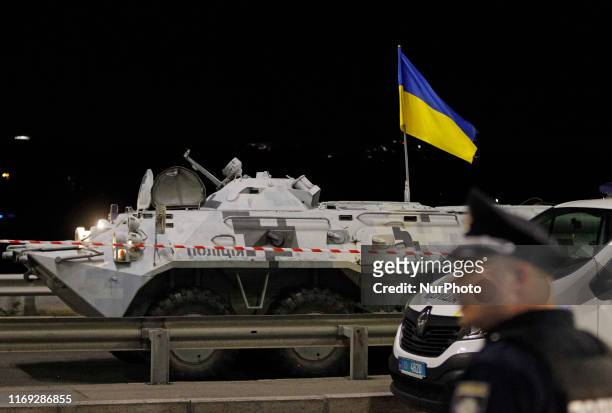 An Ukrainian police officer stands near an armored car, during an operation of Ukrainian special forces for detain a man who was threatening to blow...