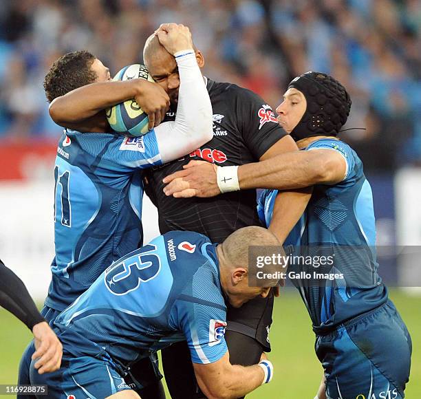 Pietersen of Sharks is tackled by Bjorn Basson, Jaco Pretorius and Pierre Spies of Bulls during the Super Rugby match between Vodacom Bulls and the...