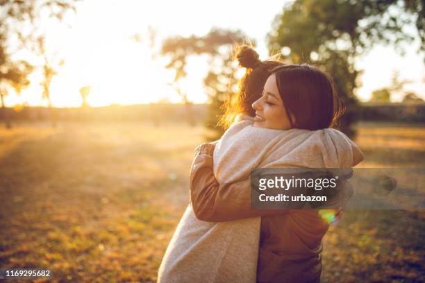 due donne che abbracciano - abbracciare una persona foto e immagini stock