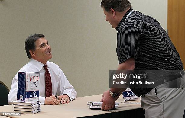 Texas governor Rick Perry signs copies of his book "Fed Up" during the 2011 Republican Leadership Conference on June 18, 2011 in New Orleans,...