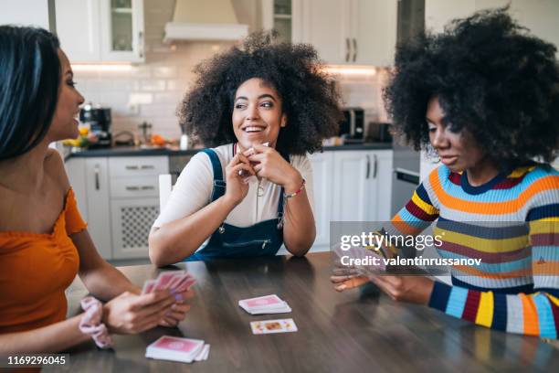 drei mädchen zu hause spielkarten - spieleabend stock-fotos und bilder