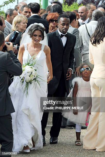French football player Sidney Govou and his wife Clemence Catherin leave the church during their wedding ceremony on June 18, 2011 in Replonges,...