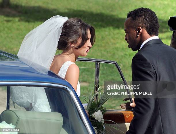French football player Sidney Govou and his wife Clemence Catherin get out of their car during their wedding ceremony on June 18, 2011 in Replonges,...
