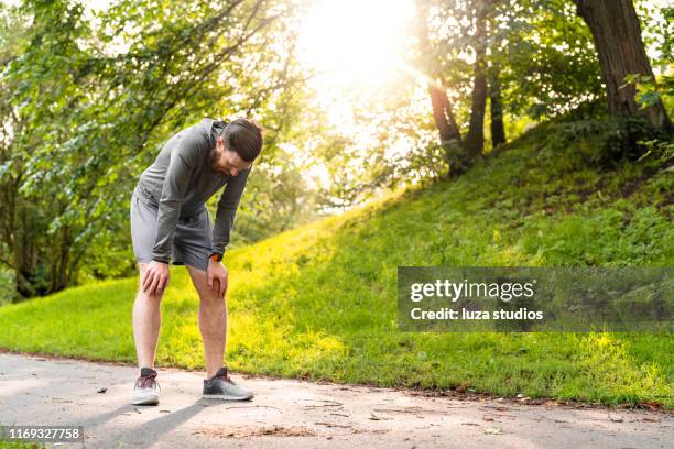 swedish man is exhausted after exercising in e public park - fatigue full body stock pictures, royalty-free photos & images