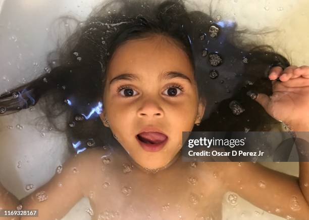 toddler in a bubble bath with face above water - bath girl stockfoto's en -beelden
