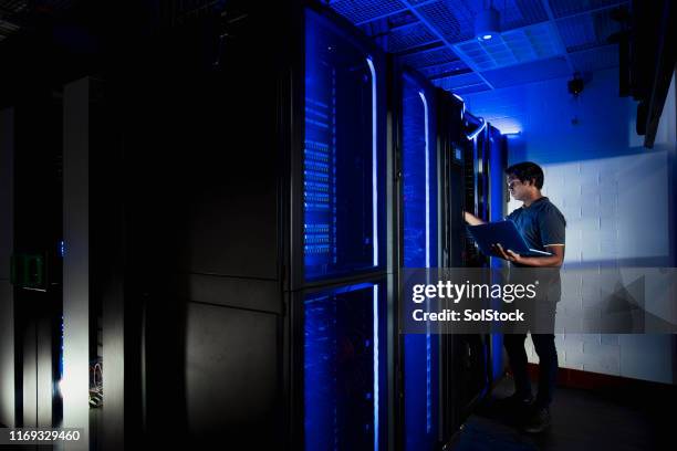 mannelijke technicus werkzaam in server ruimte - computer backup stockfoto's en -beelden