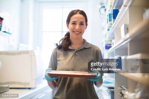 smiling woman working in a dental clinic - 後梳髮型 個照片及圖片檔