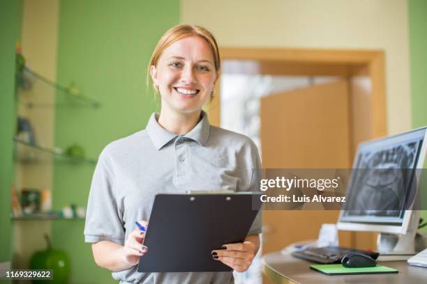 smiling young woman working at dentistry - gray polo shirt stock pictures, royalty-free photos & images