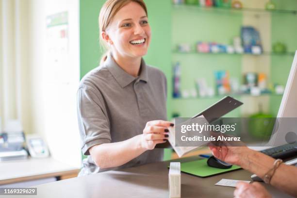 female pharmacist giving medicines to customer - sales assistant furniture stock pictures, royalty-free photos & images