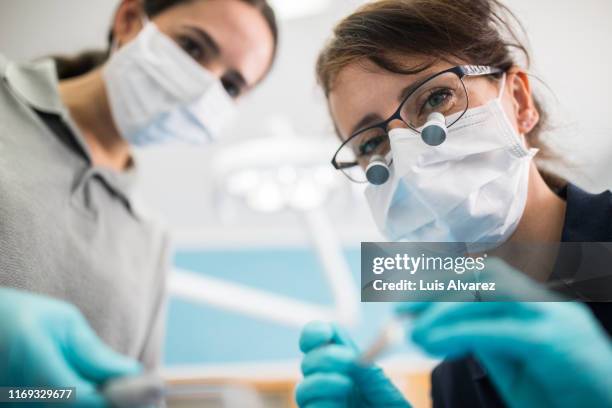 female dentist examining patient - dental care stock-fotos und bilder