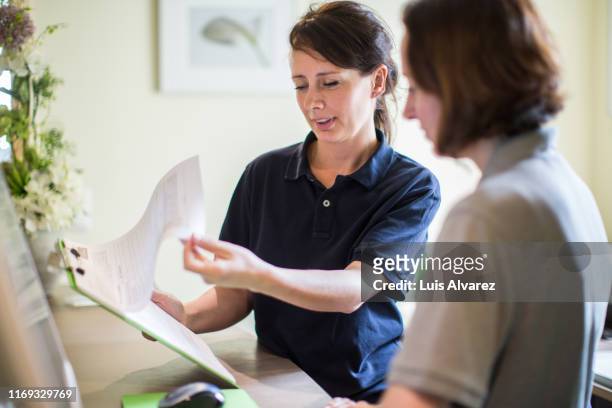 doctor reviewing at patient appointment list - customer service documents stock pictures, royalty-free photos & images
