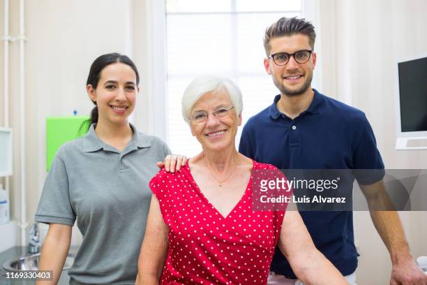 senior woman with her dental expert and nurse - navy blue polo shirt stock pictures, royalty-free photos & images