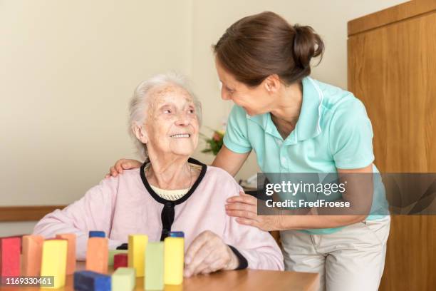 dementie – thuis verzorger en senior volwassen vrouw - ziekte van alzheimer stockfoto's en -beelden