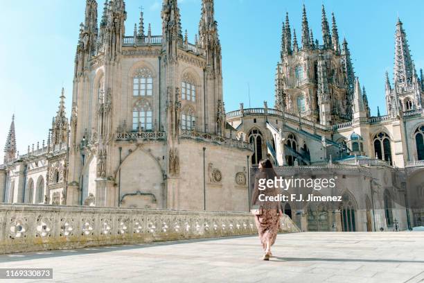 woman walking outside the cathedral of burgos - burgos stockfoto's en -beelden