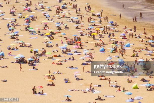 high angle view of a beach full of people, beach of barinatxe, la salvaje. - aerial beach view sunbathers stock pictures, royalty-free photos & images