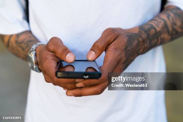 hands of tattooed man using smartphone, close-up - call to arms stock pictures, royalty-free photos & images
