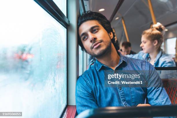 portrait of daydreaming young man travelling by bus, london, uk - bus window stock pictures, royalty-free photos & images