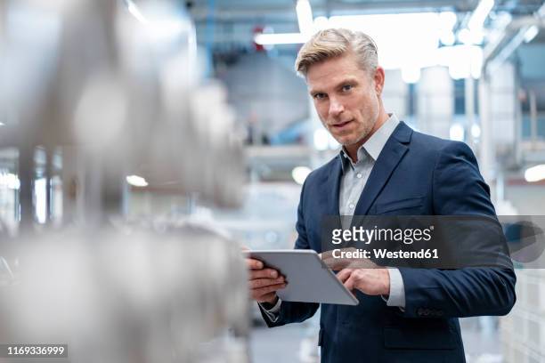 portrait of businessman with tablet in a modern factory - 40 44 years blond hair mature man factory stock pictures, royalty-free photos & images