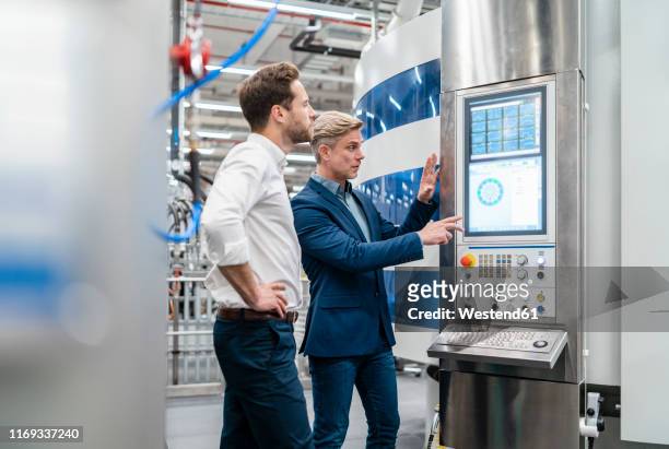 two businessmen talking in a modern factory - digitization stockfoto's en -beelden