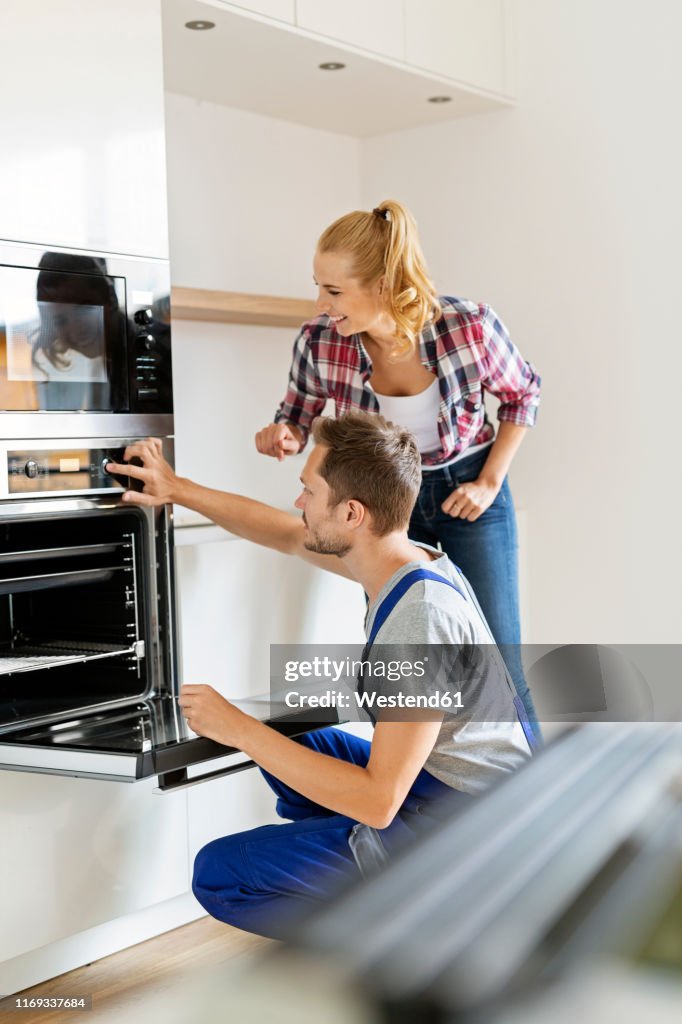 Craftsman installing new oven in kitchen