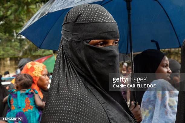 Woman wearing a niqab leaves the site after the bodies of pupils and a teacher, who were killed in an overnight fire at a Koranic school, were taken...