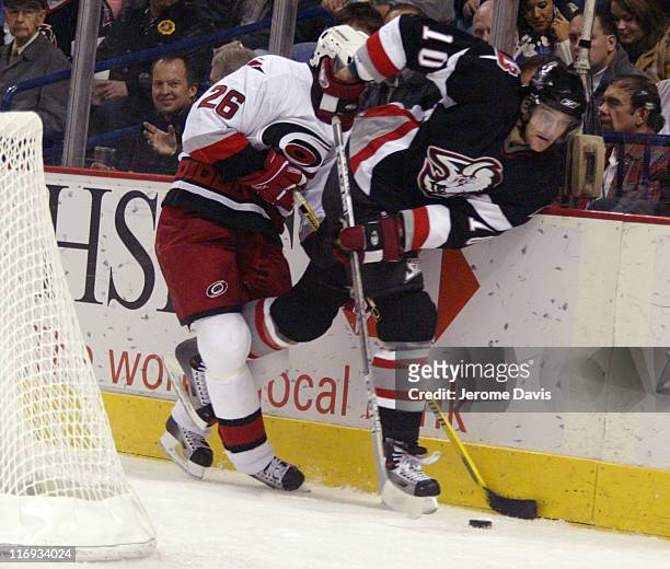 Buffalo Sabres' Henrik Tallinder is checked by Hurricanes' Erik Cole during a game against at the HSBC Arena in Buffalo, NY on November 09, 2005. The...