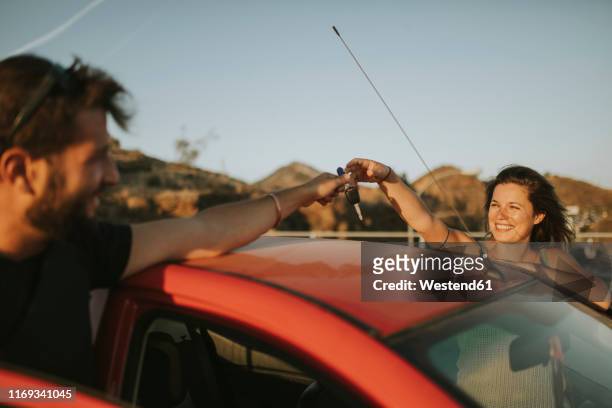 couple exchanging car keys on a road trip - handing over keys stock pictures, royalty-free photos & images