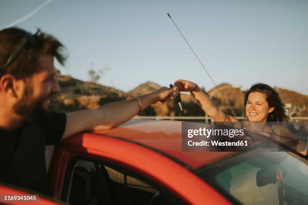 couple exchanging car keys on a road trip - handing over keys bildbanksfoton och bilder