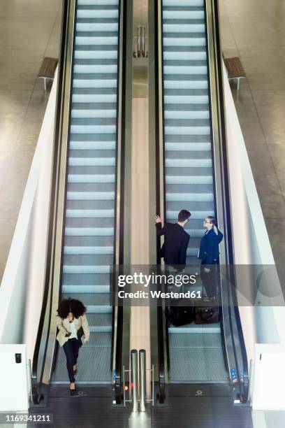 young business people on an escalator - rolltreppe von oben stock-fotos und bilder