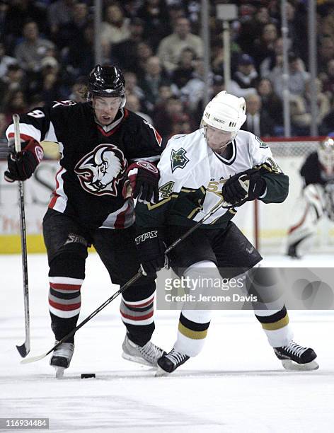 Buffalo Sabres' Derek Roy is checked by Stars' Stu Barnes during a game versus the Dallas Stars at the HSBC Arena in Buffalo, NY, December 14, 2005....