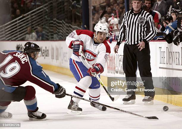 Francis Bouillon of the Montreal Canadiens sends the puck past Joe Sakic of the Colorado Avalanche during the game on January 11, 2006 at Pepsi...