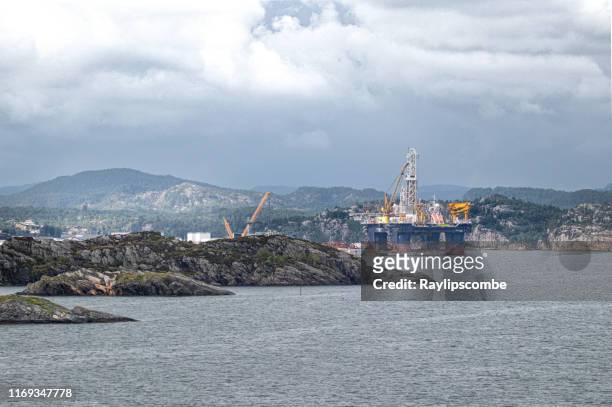 oil/gas rig set in the beautiful norwegian fjord countryside. - oil rig uk stock pictures, royalty-free photos & images