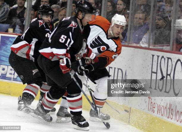 Buffalo Sabres' Brian Campbell battles Flyer's R.J. Umberger, for the lose puck during a game versus the Philadelphia Flyers at the HSBC Arena in...