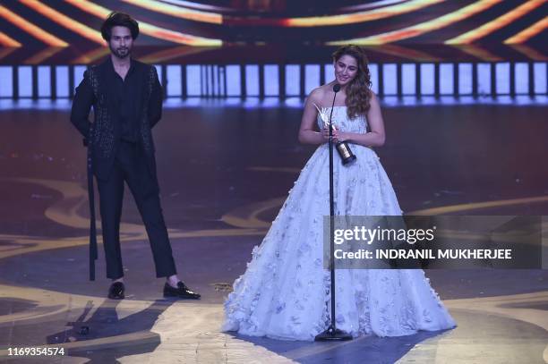 Bollywood actor Shahid Kapoor looks on as actress Sarah Ali Khan reacts after receiving the Best Debutant - Female award during the 20th...