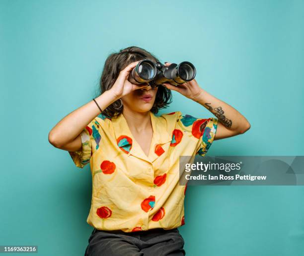 cute young woman using binoculars - canocchiale foto e immagini stock