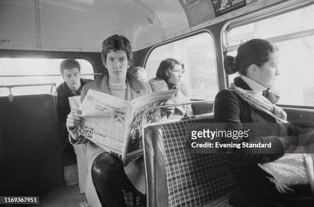 English rock guitarist, singer, actor and radio DJ Steve Jones of The Sex Pistols reads the magazine 'National RockStar' while travelling on a...