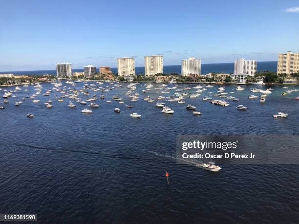 over 100 boats and yachts in water with beach and hotels in the horizon - west palm beach foto e immagini stock