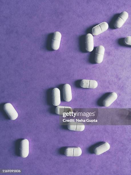 pills on purple background - paracetamol stock pictures, royalty-free photos & images